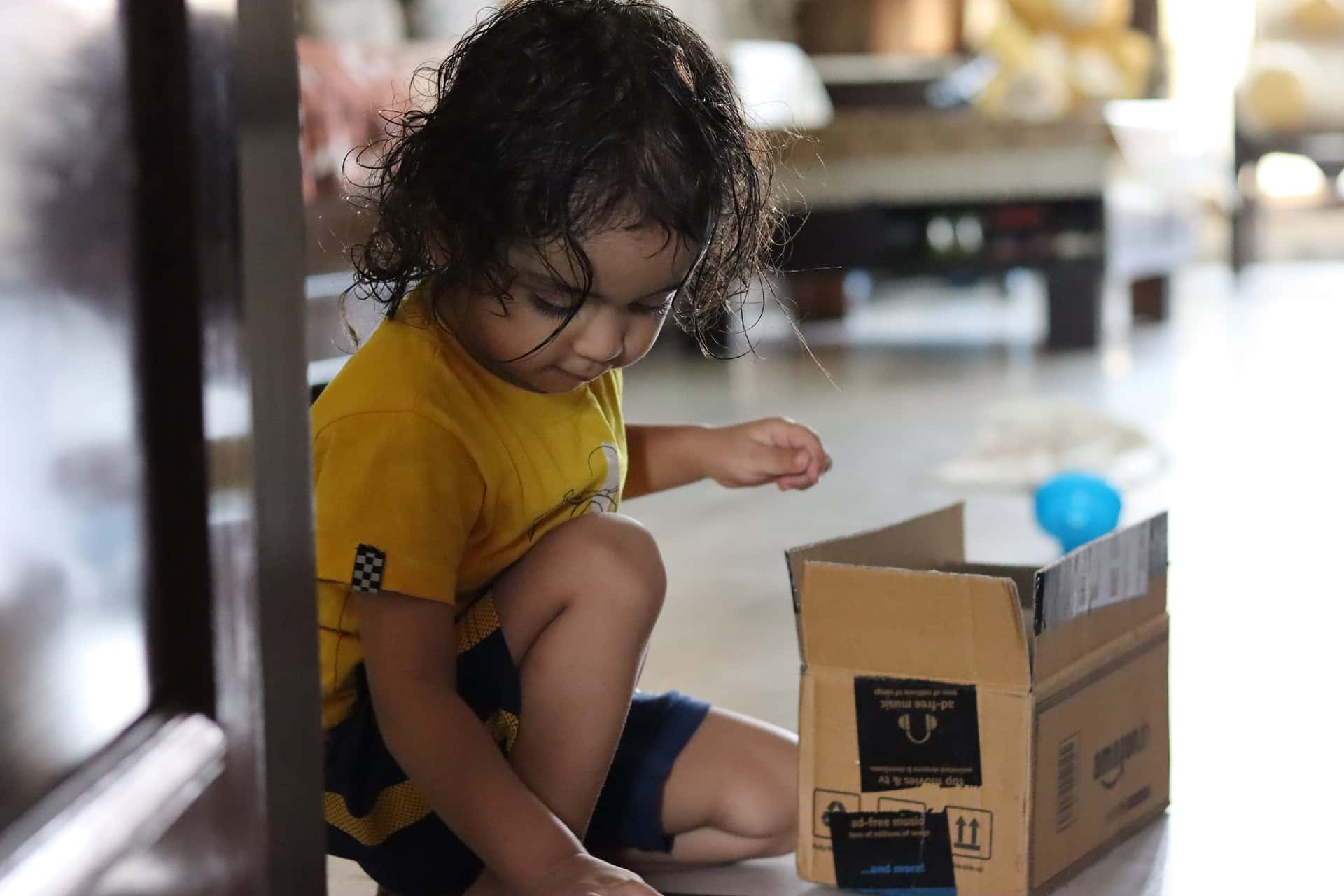 Niña jugando con caja de cartón