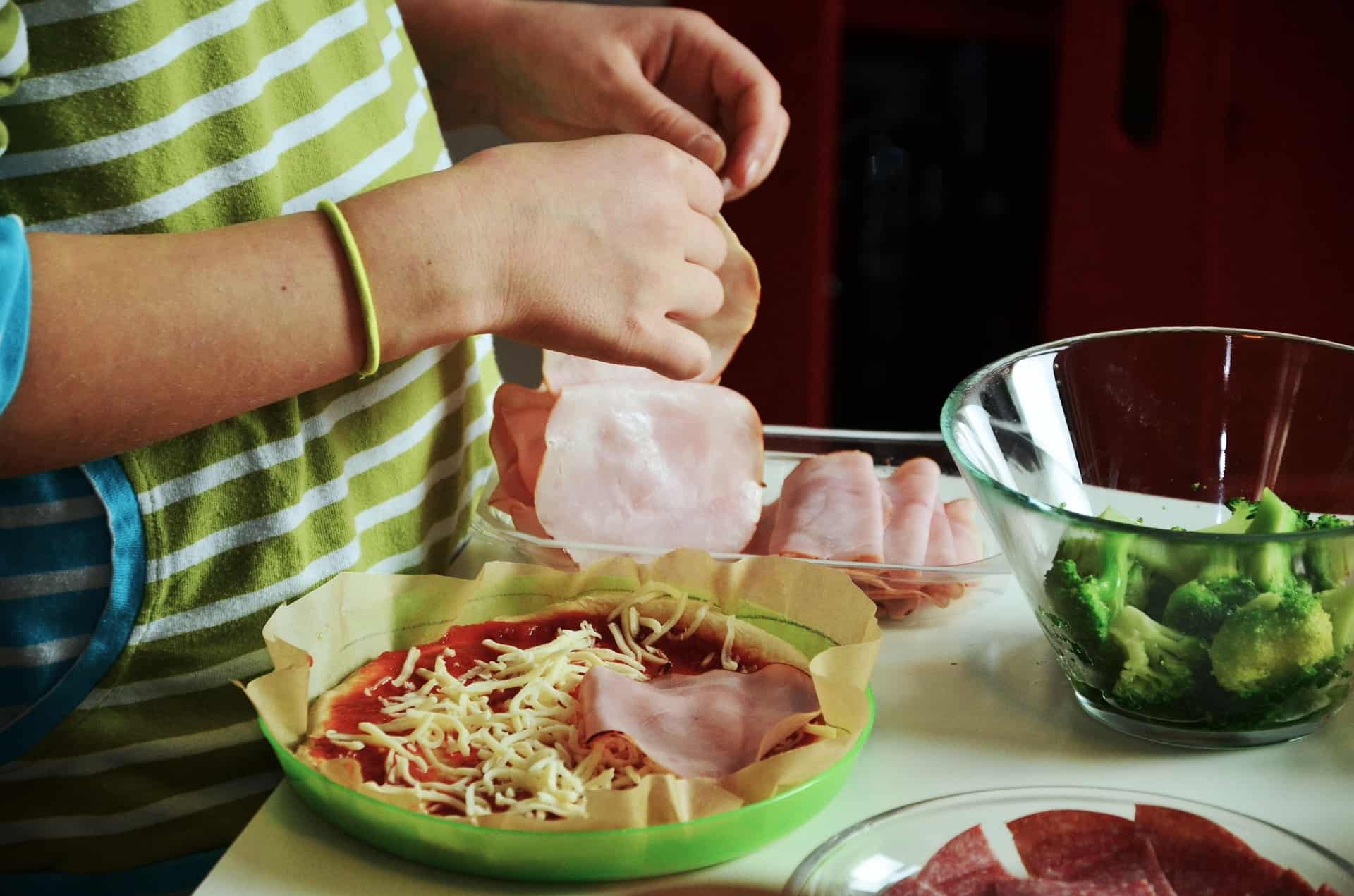 Niño cocinando una pizza